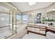 Bright bathroom with a glass enclosed shower, soaking tub, vanity, and large mirror at 9728 Ashleigh Ln, Highlands Ranch, CO 80126
