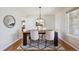 Bright dining room with modern lighting, a dark wood table, white chairs, and a patterned rug at 9728 Ashleigh Ln, Highlands Ranch, CO 80126