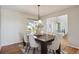Bright dining room with natural light, featuring a dark wood table, six chairs, and an open entryway at 9728 Ashleigh Ln, Highlands Ranch, CO 80126