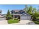 Charming two-story home with a well-manicured lawn, mature trees, and a three-car garage at 9728 Ashleigh Ln, Highlands Ranch, CO 80126