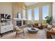 Bright living room featuring a fireplace, tall windows, and comfortable furniture at 9728 Ashleigh Ln, Highlands Ranch, CO 80126