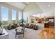 Open-concept living room with large windows, comfortable seating, and an adjacent kitchen at 9728 Ashleigh Ln, Highlands Ranch, CO 80126
