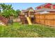 Backyard featuring a wooden playset with a slide, a rope ladder, and green grass at 10570 Worchester Dr, Commerce City, CO 80022