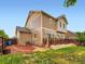 Back exterior of home featuring a wooden deck, grass, and various windows and siding at 10570 Worchester Dr, Commerce City, CO 80022