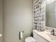 Bathroom featuring a patterned accent wall and modern fixtures at 10570 Worchester Dr, Commerce City, CO 80022