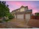 Beautiful two-story home with a three-car garage and stone accents under a lovely pink sky at 10570 Worchester Dr, Commerce City, CO 80022