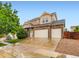 Beautiful two-story home with a three-car garage and stone accents under a clear sky at 10570 Worchester Dr, Commerce City, CO 80022