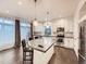 Bright kitchen showcasing an island, granite counters, stainless appliances, white cabinets, and hardwood floors at 10570 Worchester Dr, Commerce City, CO 80022