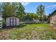 Spacious backyard featuring a shed, grassy area, and white fence, perfect for outdoor activities and storage at 7998 Faith Ct, Frederick, CO 80530