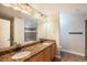 Bathroom with double sinks, granite countertops, and a shower with decorative tile at 7998 Faith Ct, Frederick, CO 80530