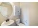 Powder room with a pedestal sink, storage cabinet, and a decorative oval mirror at 7998 Faith Ct, Frederick, CO 80530