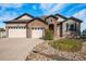 Charming two-story home featuring a stone facade, three-car garage, and well-manicured landscaping at 7998 Faith Ct, Frederick, CO 80530