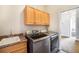 Well-equipped laundry room featuring a sink, cabinetry, and modern washer and dryer at 7998 Faith Ct, Frederick, CO 80530