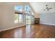 Bright living room featuring hardwood floors, large windows, and a stone fireplace at 7998 Faith Ct, Frederick, CO 80530
