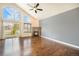 Bright living room with hardwood floors, large windows, and a stone fireplace at 7998 Faith Ct, Frederick, CO 80530