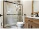Modern bathroom featuring a glass-enclosed shower and wood-style vanity at 3165 W 63Rd Ave, Denver, CO 80221