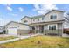 Inviting two-story home featuring a manicured lawn, stone accents, and an attached two-car garage at 3165 W 63Rd Ave, Denver, CO 80221