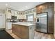 Modern kitchen features stainless steel appliances, granite counters, tiled backsplash, and wood-look flooring at 3165 W 63Rd Ave, Denver, CO 80221