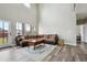 Open living room showcasing high ceilings, hardwood floors, and a seating arrangement with an area rug at 3165 W 63Rd Ave, Denver, CO 80221