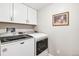 Bright laundry room with front loading washer and dryer and overhead cabinets for storage at 13961 E Marina Dr # 414, Aurora, CO 80014