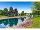 Scenic community pond featuring rock borders, mature trees, and a tranquil fountain for relaxation and natural beauty at 13961 E Marina Dr # 414, Aurora, CO 80014