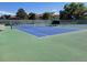 Brightly colored tennis court with a net and shaded seating for an active lifestyle and friendly matches at 13961 E Marina Dr # 414, Aurora, CO 80014