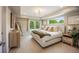 Bedroom with a large bed, bright windows, and views of lush greenery at 3690 W Byron Pl, Denver, CO 80211
