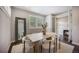 Bright dining room with wooden table, white chairs, and natural light streaming through the window at 3690 W Byron Pl, Denver, CO 80211