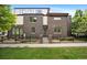 Contemporary brown brick home with a black fence, manicured lawn and garden at 3690 W Byron Pl, Denver, CO 80211
