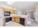 Bright kitchen featuring wood cabinets, black appliances, and a pass-through to the living area at 4875 S Balsam Way # 6-102, Littleton, CO 80123