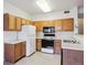 Functional kitchen showcasing ample wood cabinets, black appliances, and bright lighting at 4875 S Balsam Way # 6-102, Littleton, CO 80123