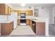 Well-lit kitchen with wood cabinetry, updated appliances, and tiled flooring at 4875 S Balsam Way # 6-102, Littleton, CO 80123