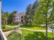 Well-maintained condo building with lush landscaping, mature trees, and convenient walking paths at 7700 N Depew St # 1518, Arvada, CO 80003