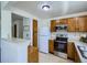 Bright kitchen features oak cabinets, white appliances, and a breakfast bar overlooking the adjacent room at 7700 N Depew St # 1518, Arvada, CO 80003