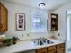 Efficient kitchen with white countertops, wooden cabinets, and stainless-steel sink under a bright window at 7700 N Depew St # 1518, Arvada, CO 80003