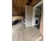 A partially covered back porch reveals an untidy area, a worn grill, and a door leading to the home's interior at 2655 Pontiac St, Denver, CO 80207