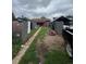 A disorganized backyard displaying numerous refrigerators, an old lawnmower, and a distressed lawn area at 2655 Pontiac St, Denver, CO 80207