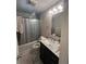 A compact bathroom features a patterned shower curtain, a dark vanity, and a well-lit mirror at 2655 Pontiac St, Denver, CO 80207