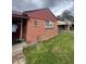 Side view of the brick house showing the well-kept lawn and traditional design elements at 2655 Pontiac St, Denver, CO 80207