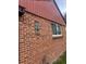 Detailed view of the brick exterior with a small, unique window feature at 2655 Pontiac St, Denver, CO 80207