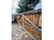A weathered wooden fence is shown in disrepair with damaged slats and aging hardware in a backyard setting at 2655 Pontiac St, Denver, CO 80207