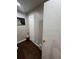 Hallway with dark hardwood floors, white trim, and a wall with a framed artwork, accented by a small backpack at 2655 Pontiac St, Denver, CO 80207