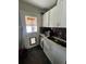 A well-lit kitchen featuring a modern stainless steel sink, sleek white cabinets, and a convenient door with a pet door at 2655 Pontiac St, Denver, CO 80207