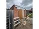 Exterior shot of a brick shed with a worn-out door, surrounded by clutter and an unkempt yard at 2655 Pontiac St, Denver, CO 80207