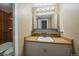 Bathroom featuring tile walls, white sink with storage and a large mirror with modern lighting at 4801 E 9Th Ave # 108S, Denver, CO 80220