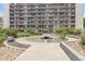 Beautiful condo building exterior with balconies, a fountain, landscaping, and lovely outdoor seating at 4801 E 9Th Ave # 108S, Denver, CO 80220