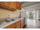 Bright kitchen with wood cabinets and appliances, next to a sliding glass door and wood floors at 4801 E 9Th Ave # 108S, Denver, CO 80220