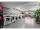 Well-lit laundry room featuring multiple washing machines with an open exit leading to outside at 4801 E 9Th Ave # 108S, Denver, CO 80220