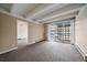 Well-lit living room featuring exposed beam ceilings, carpet floors, and access to an outdoor patio space at 4801 E 9Th Ave # 108S, Denver, CO 80220