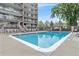 Outdoor pool area with lounge chairs, a wooden fence, and greenery nearby at 4801 E 9Th Ave # 108S, Denver, CO 80220